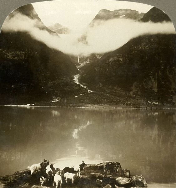 Grytereids glacier glittering above drifting clouds, across placid Lake Olden, Norway, c1905