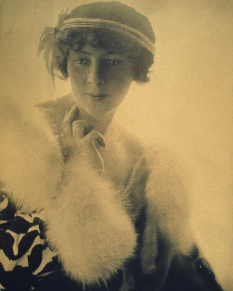 Half-length portrait of a woman wearing a fur trimmed coat, facing front, between 1900 and 1920. Creator: Unknown