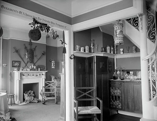 Hallway with liquor cabinet and living room decorated with mistletoe ball and Christm... c1900-1915 Creator: Unknown