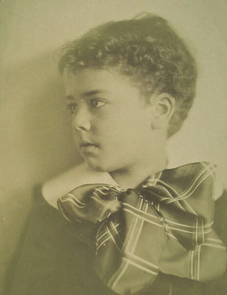 Head-and-shoulders portrait of a young boy with a large plaid bow at the neck of his... c1900. Creator: Horace L Bundy