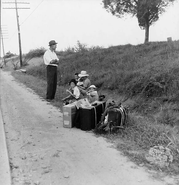 A hitchhiking family waiting along the highway in Macon, Georgia, 1937. Creator: Dorothea Lange
