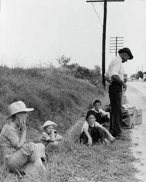 A hitchhiking family waiting along the highway in Macon, Georgia, 1937. Creator: Dorothea Lange