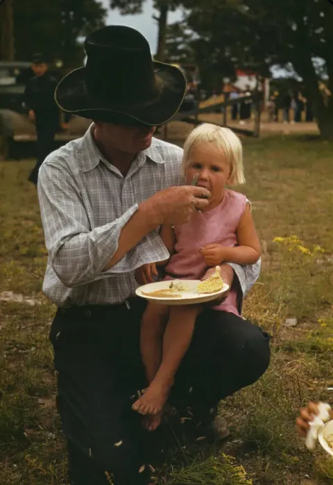 Framed Print : Homesteader feeding his daughter at the Pie Town, New Mexico Fair free barbeque, 1940. Creator: Russell Lee Framed Print : Homesteader feeding his daughter at the Pie Town, New Mexico Fair free barbeque, 1940. Creator: Russell Lee