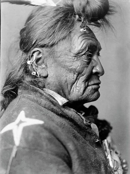 Hoop On the Forehead, Crow Indian, Montana, head-and-shoulders portrait, facing right, c1908. Creator: Edward Sheriff Curtis