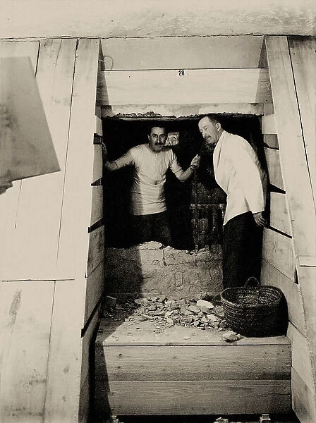 Howard Carter (left) and Lord Carnarvon break through into the inner tomb, 1923. Creator: Burton, Harry (1879-1940)