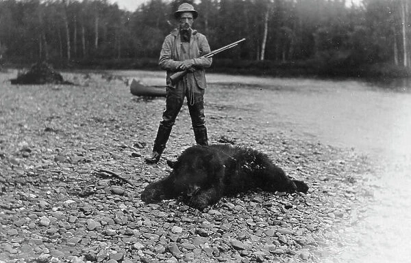 Hunter with bear which he killed, between c1900 and 1927. Creator: Unknown