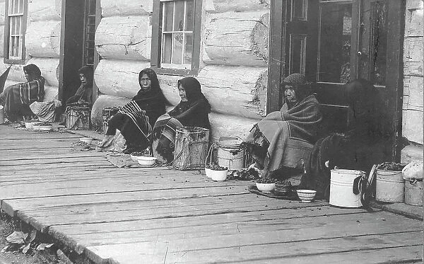 Indians sitting with backs to wall selling berries, between c1900 and c1930. Creator: Unknown