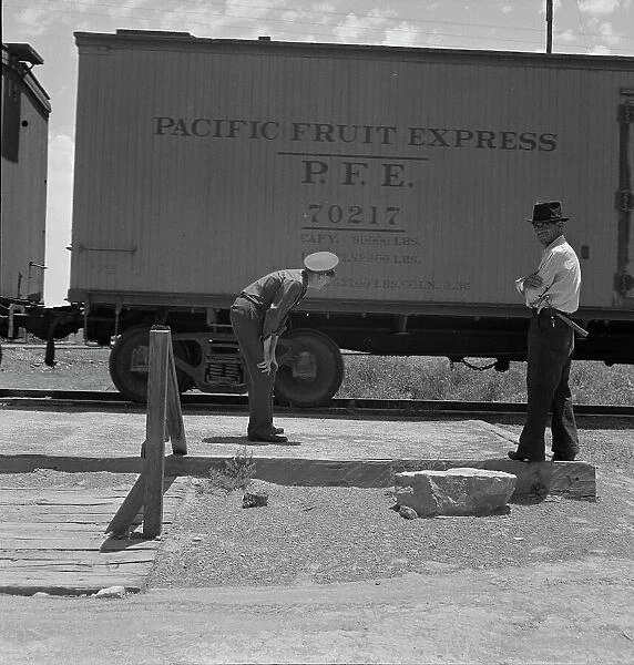 Inspecting a freight train from Mexico for smuggled immigrants, El Paso, Texas, 1938. Creator: Dorothea Lange