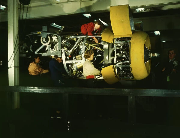 Installing one of the 4 motors on the transport plane at Willow Run, between 1941 and 1945. Creator: Howard Hollem