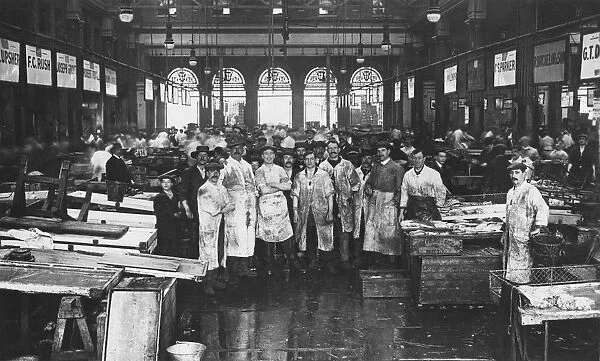 The interior of Billingsgate Market showing fishmongers and their stalls, London, c1918
