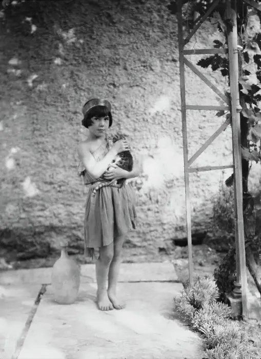 Framed Print : Kanellos child in dance costume holding a cat, 1929 Creator: Arnold Genthe Framed Print : Kanellos child in dance costume holding a cat, 1929 Creator: Arnold Genthe