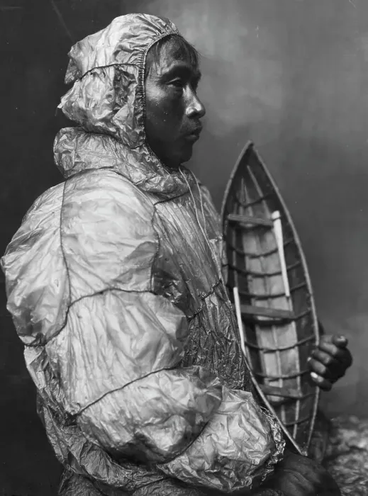 Framed Print : Kayaker wearing water-proof jacket with toy boat he made for his son, between c1900 and c1930. Creator: Lomen Brothers Framed Print : Kayaker wearing water-proof jacket with toy boat he made for his son, between c1900 and c1930. Creator: Lomen Brothers
