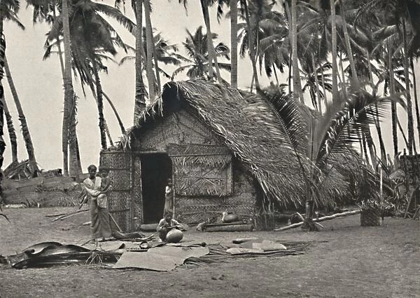 Kokospalmen und Einngeborenenhutte aus Kokosblattern (An den Stammen links, angebundene Blatter geg