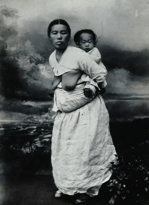 Framed Print : A Korean (?) woman, carrying a baby on her back, approx 1900. Creator: Unknown Framed Print : A Korean (?) woman, carrying a baby on her back, approx 1900. Creator: Unknown