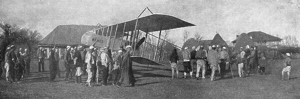 La retraite de nos aviateurs par l'Albanie; Biplan entoure par la population masculine... 1916. Creator: Unknown
