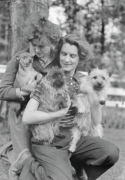 Le Gallienne, Eva, and unidentified woman, with dogs, outdoors, 1937 Creator: Arnold Genthe