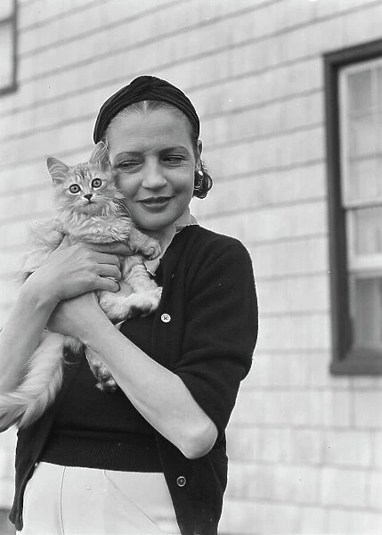 Leonard, Mrs. with cat, standing outdoors, between 1926 and 1938. Creator: Arnold Genthe