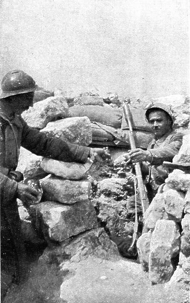 Life in the trenches in Champagne; A lookout teased by the enemy is passed hand grenades, 1917. Creator: Unknown