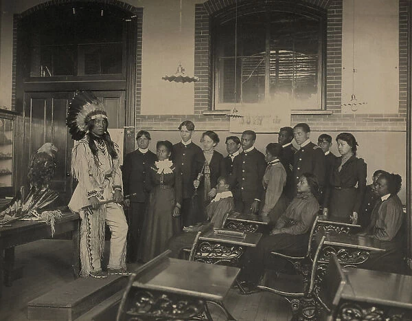 Louis Firetail (Sioux, Crow Creek), wearing tribal clothing, in American history... 1899 or 1900. Creator: Frances Benjamin Johnston