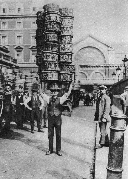 A man carrying many baskets on his head, Covent Garden, London, 1926-1927