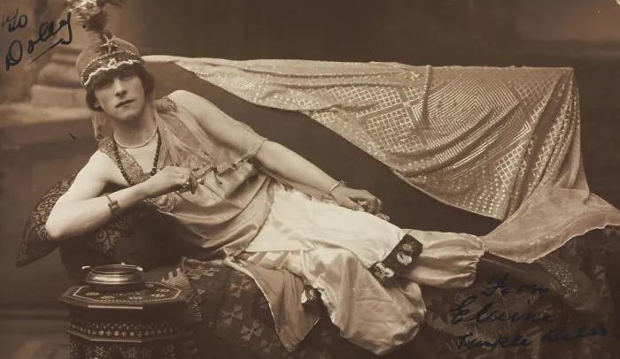 Framed Print : A man in drag poses wearing delicate attire; curled up on a piece of furniture, [1910-1919?]. Creator: Unknown