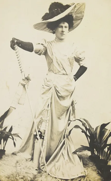 Framed Print : An man in drag is wearing a revealing dress and holding a staff, posing with his... 1909. Creator: Unknown Framed Print : An man in drag is wearing a revealing dress and holding a staff, posing with his... 1909. Creator: Unknown