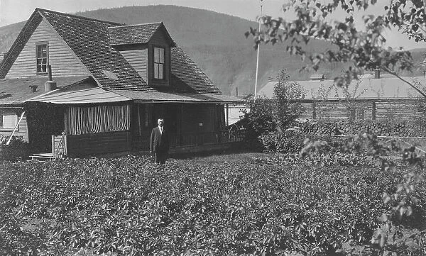 Man in frontyard of house, between c1900 and 1916. Creator: Unknown