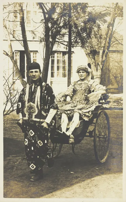 Framed Print : A man in ornate drag sits in a dog-cart and is pulled along the road by...(between 1910 and 1919?). Creator: Unknown Framed Print : A man in ornate drag sits in a dog-cart and is pulled along the road by...(between 1910 and 1919?). Creator: Unknown