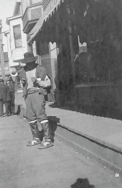 Man outside store, between c1900 and 1916. Creator: Unknown