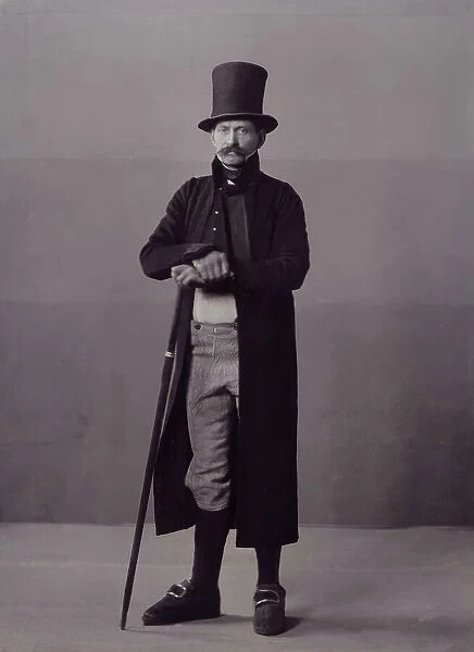 A man poses in folk costume with a long coat and a top hat, 1880-1907. Creator: Helene Edlund