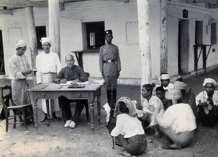 Framed Print : A man sitting at a table examining passports, during a plague epidemic in Mandalay, 1906. Creator: Unknown Framed Print : A man sitting at a table examining passports, during a plague epidemic in Mandalay, 1906. Creator: Unknown