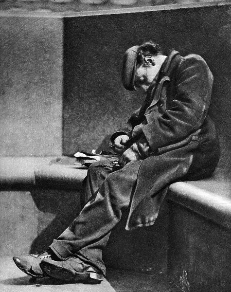 A man sleeping on Blackfriars Bridge, London, 1926-1927. Artist: Walter Benington
