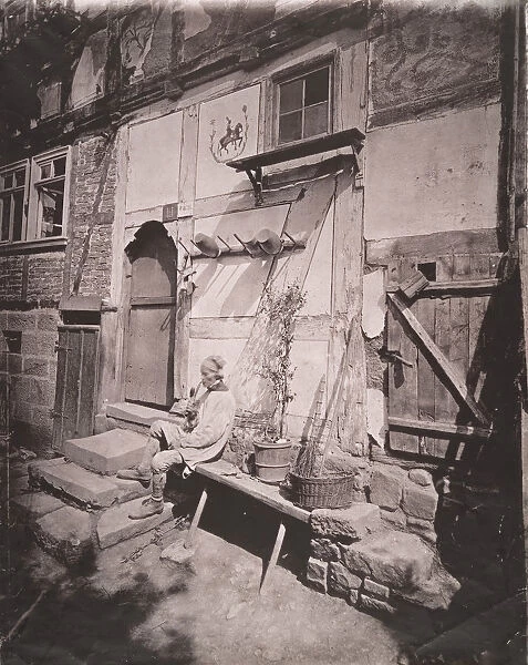 [Man Smoking Pipe Outside His Home on Village Street], 1880s. Creator: Unknown