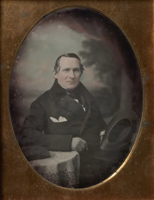 Framed Print : Man Wearing Coat and Gloves, Holding Hat, Seated in Front of Painted Outdoor Backdrop Framed Print : Man Wearing Coat and Gloves, Holding Hat, Seated in Front of Painted Outdoor Backdrop