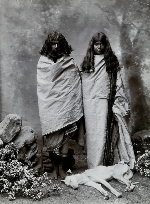Framed Print : A man and woman of the Toda tribe standing in a photographic studio, with a dog lying... c1900. Creator: Unknown Framed Print : A man and woman of the Toda tribe standing in a photographic studio, with a dog lying... c1900. Creator: Unknown