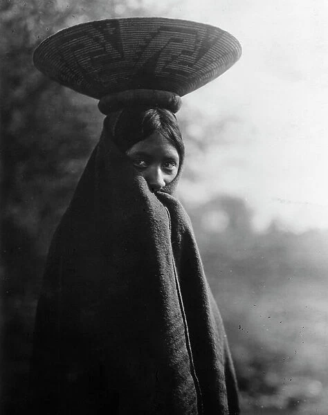 Maricopa girl, half-length portrait, standing, facing slightly right, wrapped in blanket... c1907. Creator: Edward Sheriff Curtis