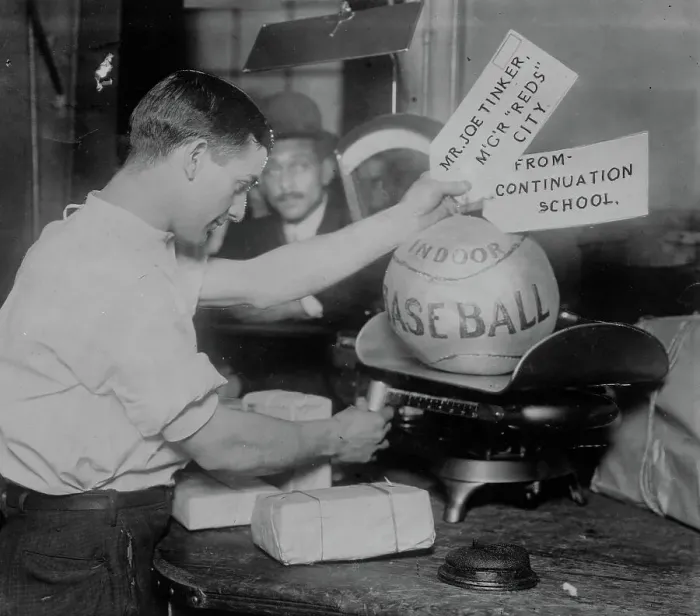 Framed Print : Medicine ball being weighed by Post Office employee; shipping tags read: Mr. Joe Tinker... 1913. Creator: Bain News Service