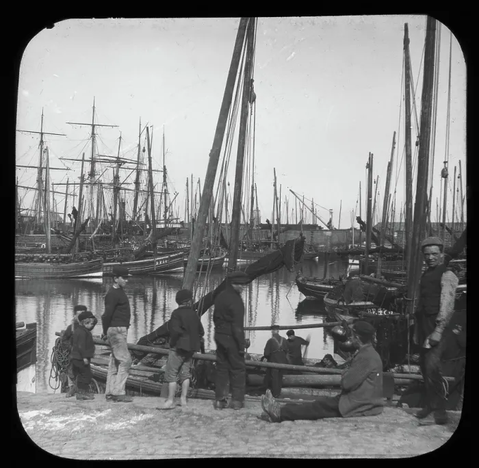 Framed Print : Men and boys with sailing boats in port, unknown location, c1900s Framed Print : Men and boys with sailing boats in port, unknown location, c1900s