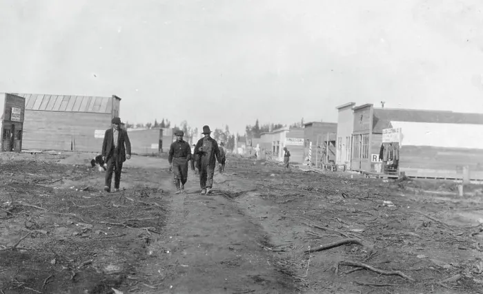 Framed Print : Three men walking down a dirt road, through town, between c1900 and 1916. Creator: Unknown Framed Print : Three men walking down a dirt road, through town, between c1900 and 1916. Creator: Unknown