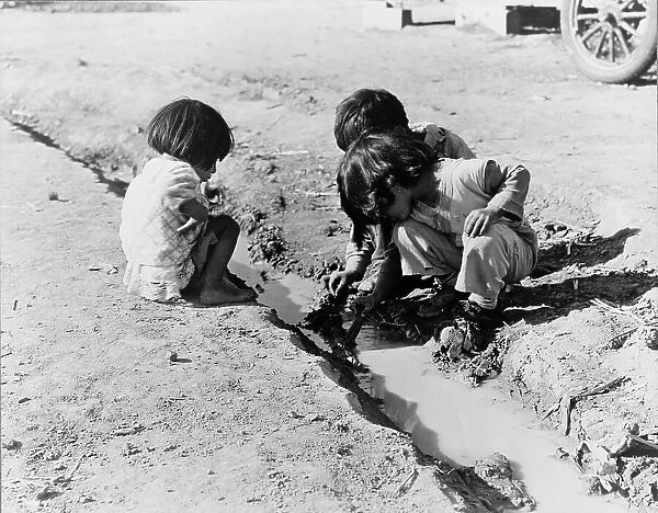 Mexican children playing in ditch, near Corcoran, California, 1936. Creator: Dorothea Lange