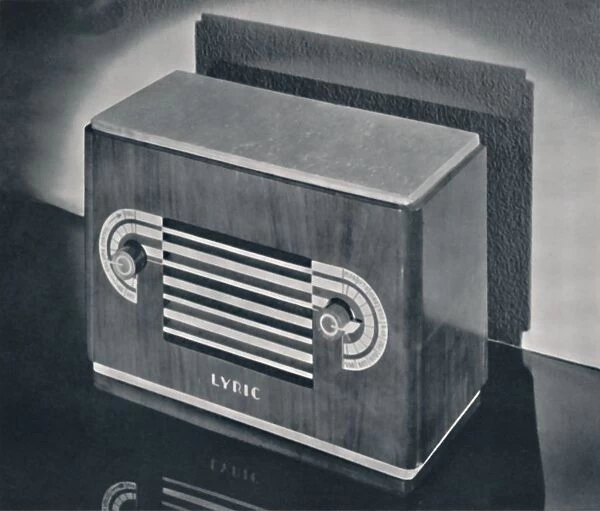 A midget radio cabinet in wood veneer, with aluminum grill and dials, 1935. Artist: Dana Merrill
