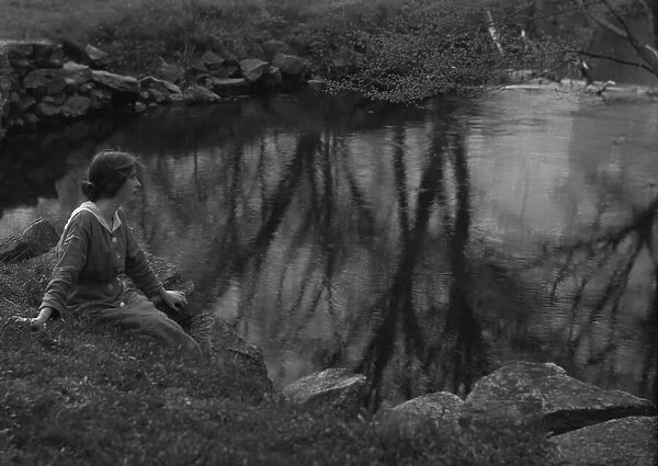 Millay, Edna St. Vincent, Miss, seated next to a pond, 1914. Creator: Arnold Genthe