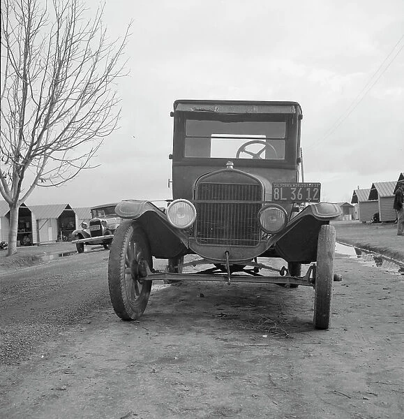 Model T Fords still carry migrants, FSA migratory labor camp at Farmersville, CA, 1939. Creator: Dorothea Lange