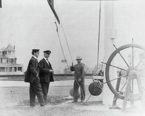 New York Yacht Club, Oyster Bay, L.I. 1905: 2 men watching sailor hoist flag, 1905. Creator: Frances Benjamin Johnston