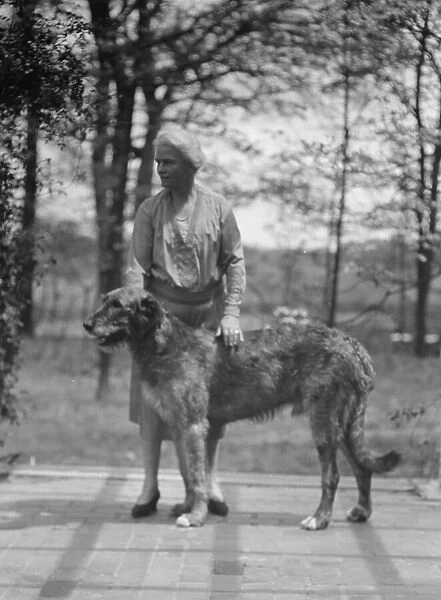 Noland, Charlotte, Miss, with dog, standing outdoors, 1931 May 8. Creator: Arnold Genthe