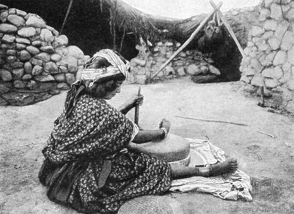 A nomad maid of the mill preparing couscous, Algeria, 1922. Artist: A Bougaut