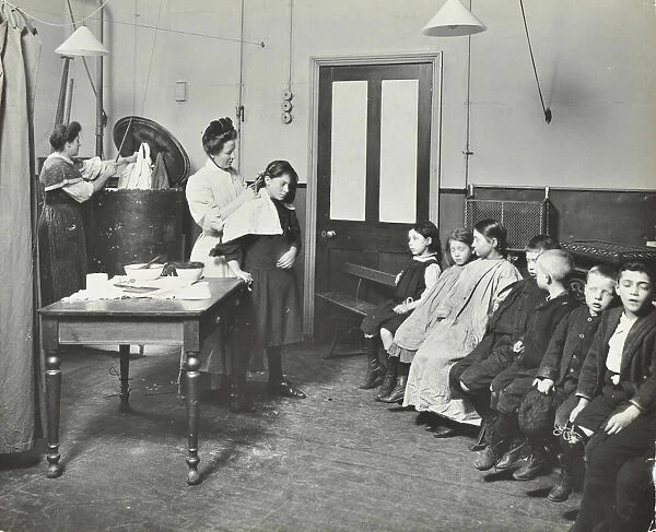 Nurse cutting childrens verminous hair, Finch Street Cleansing Station, London, 1911