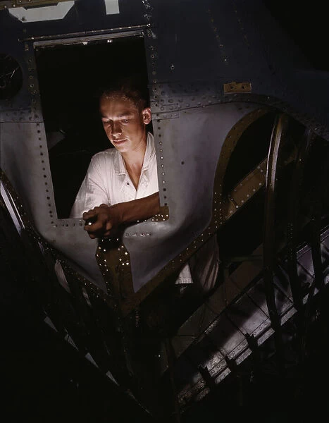 As an NYA trainee working inside the nose of a PBY, Elmer J. Pace... Corpus Christi, Texas, 1942. Creator: Howard Hollem