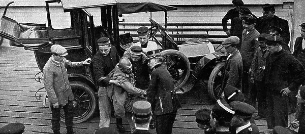 a Ostende des Belges consacrent d'infinies precautions au transport d'un blesse allemand, 1914. Creator: Unknown