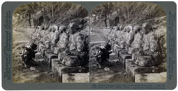Peasant praying before a row of statues of the God of Light, Daiya river, Nikko, Japan, 1904. Artist: Underwood & Underwood